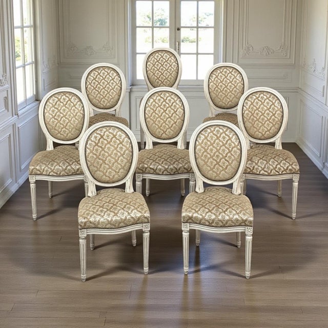 Set of 8 Antique French Louis XVI Painted Dining Chairs brings refined neoclassical grace to the dining room, with a...