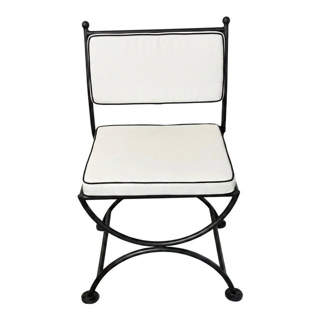This striking vintage campaign-style side chair seamlessly blends timeless European classicism with rugged durability....