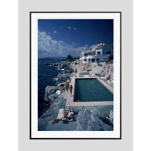 Hotel du Cap Eden-Roc' by Slim Aarons Open Edition Guests by the pool at the Hotel du Cap Eden-Roc, Antibes, France,...