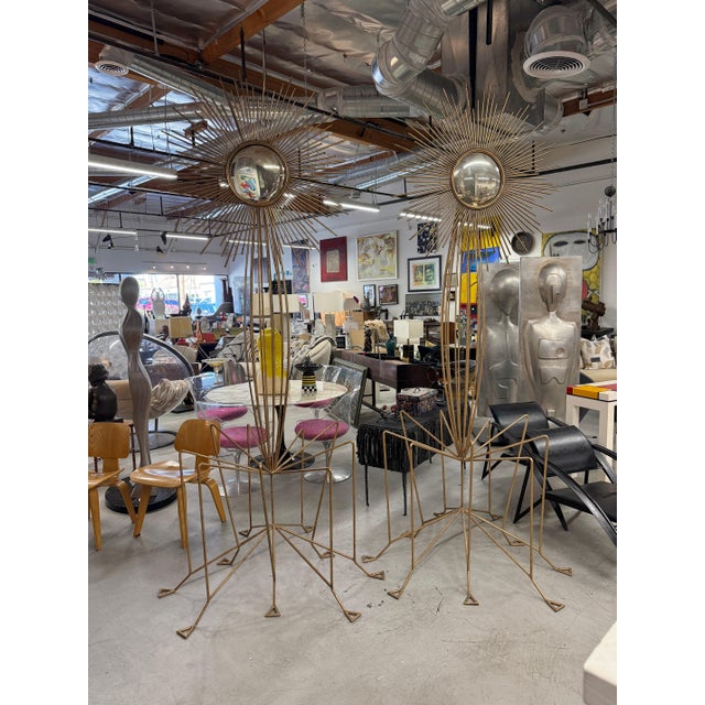 A pair of massive hand crafted brutalist sculptures with sun/star burst mirrors on top. They are each welded and bent...