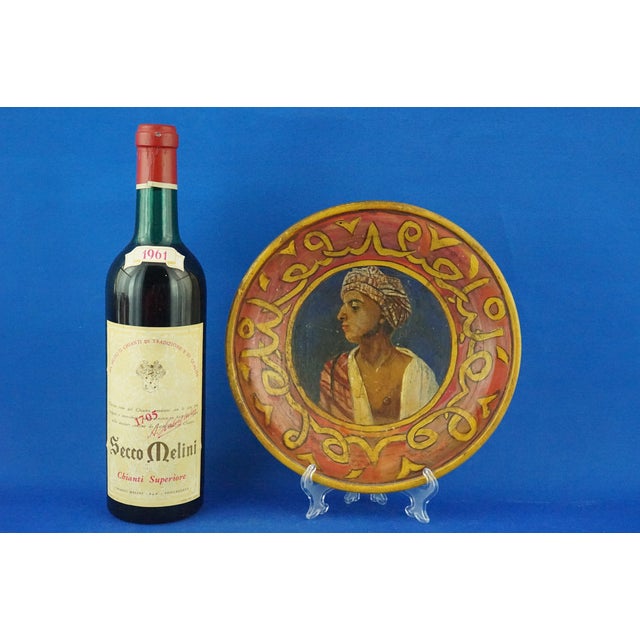 Item description: Glazed terracotta plate entirely decorated by hand with a bust of a Bedouin wearing a turban portrayed...