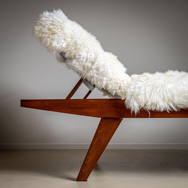 A spacious mid-century wooden daybed featuring an adjustable headrest and elegantly tapered legs. Recently reupholstered...