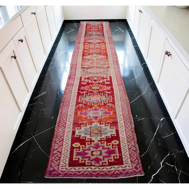 Handcrafted during the 1970s in Southeastern Anatolia, this exquisite vintage hand-knotted runner rug showcases a...