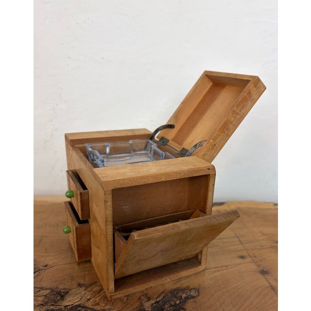 This beautiful object is a mid-20th-century art deco burr-wood smoker's cabinet (or cigarette dispenser box), typically...