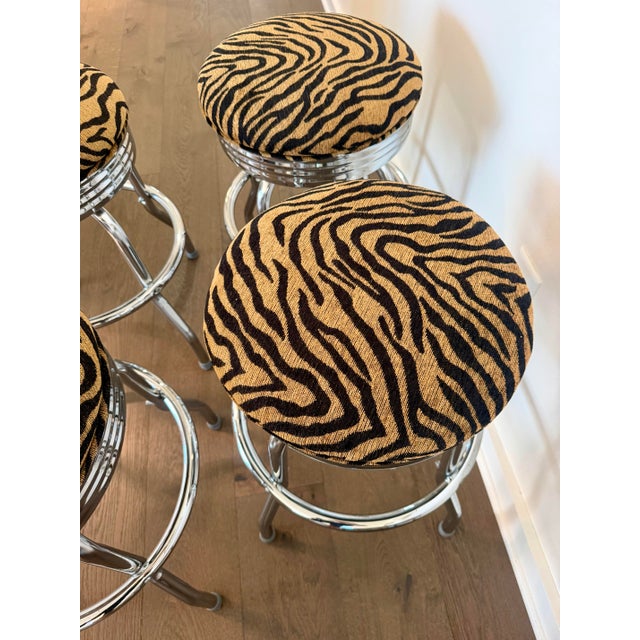 A statement-making set of four vintage counter stools with polished chrome frames and newly upholstered gold-and-black...