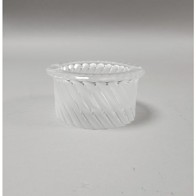 This exquisite Lalique ashtray in the Smyrne pattern features a sculptural swirl design in clear and frosted blown glass....