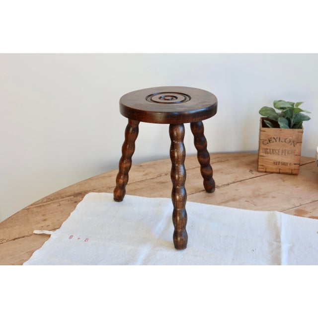 Charming antique wooden tripod milking stool, with its three turned legs and beautiful dark brown patina that gives it a...