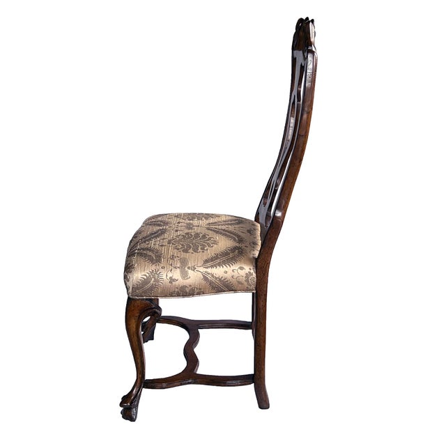 each hand-carved chair featuring a tall openwork back above a vasi-form splat; all over a tight upholstered seat raised on...