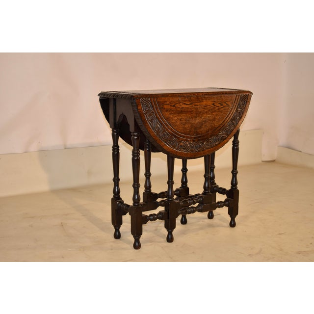 19th century hand carved oak gate leg table from England. This is a lovely side table. The top is made from wonderfully...