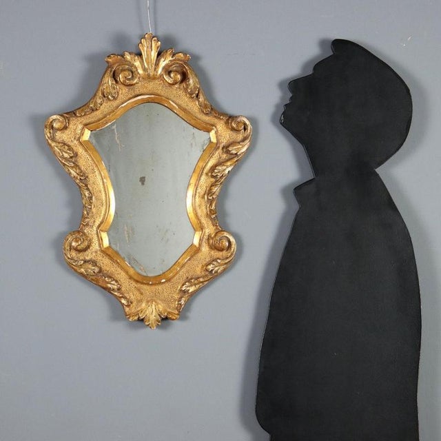 Small carved and gilded wooden mirror. Leaf carvings and curls throughout, minor losses. Italy, 19th century. This piece...