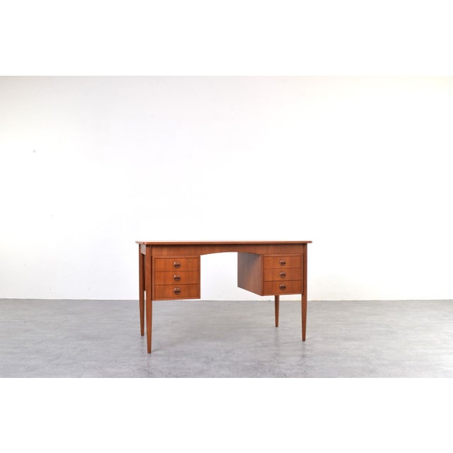 This Danish teak desk from the 1960s reflects the Scandinavian Modern style, which emphasizes functionality, clear...