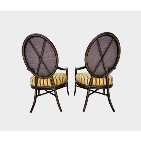 An excellent pair of oval x-back dining chairs designed by Barbara Barry for The Mcguire Company. Finish: Dark Tobacco...
