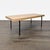 This EQ3 coffee table features a sturdy wood top and sleek black metal legs, offering a modern and minimalist look....