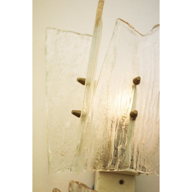This wall light was designed by j. T. Kalmar and produced by kalmar in austria in the 1960s. It is made up of a steel...