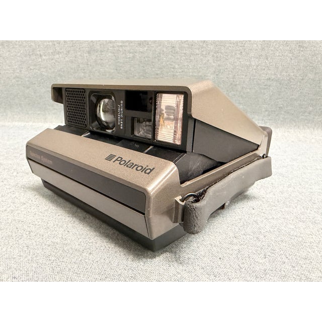 A vintage Polaroid Spectra camera that includes a remote, transmitter, manual, and case. The Instant Spectra camera was...