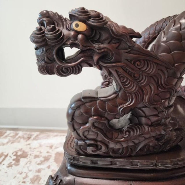 This dramatic armchair is a tour-de-force of Meiji-period craftsmanship. Profusely carved in high relief with a twin-...