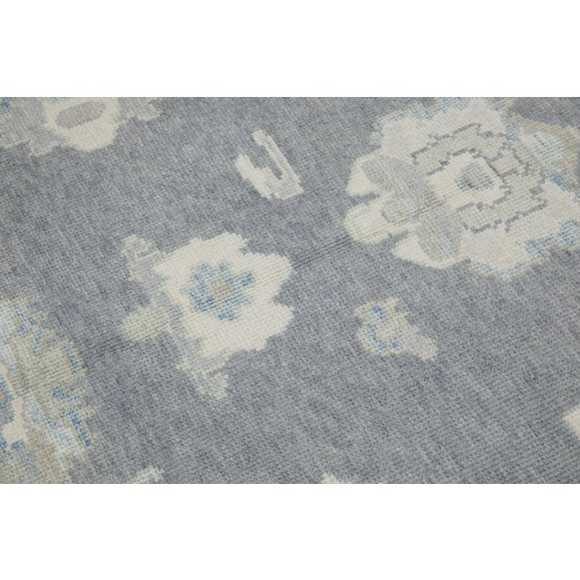 This modern Turkish Oushak rug is a stunning piece of art that has been handwoven using traditional techniques by skilled...