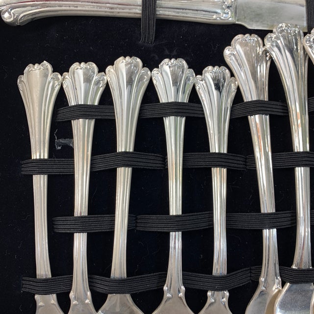 Offered here is a complete set of vintage flatware service in its original black storage chest. This specific set is the...