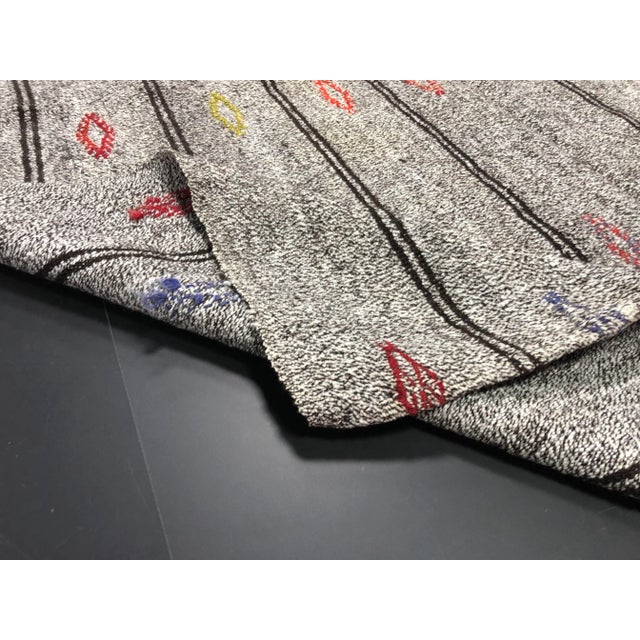 This is a vintage wool kilim rug. The piece was made in Turkey in the '60s.