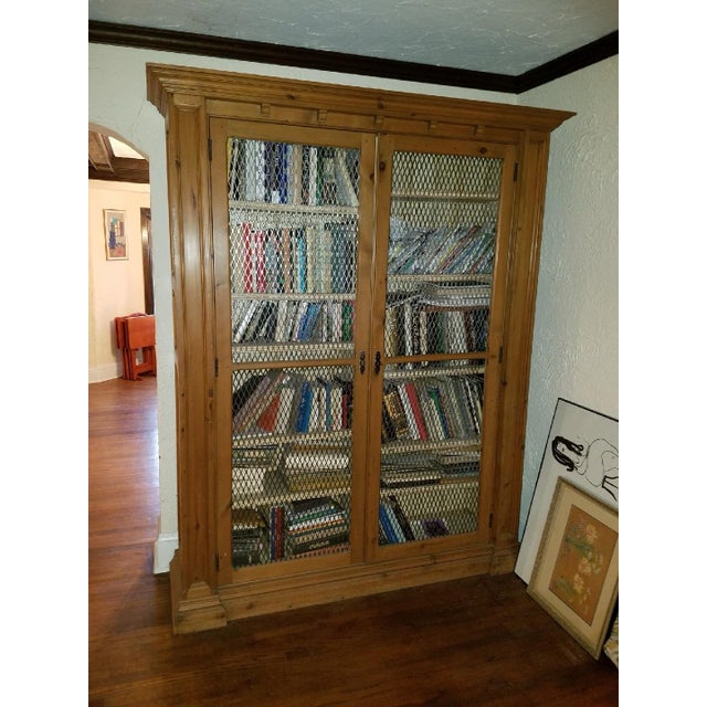 Grand antique ca 1910 solid English pine double bookcase with screened doors. 7’ H x 6’ L x 20” D dimensions with top and...