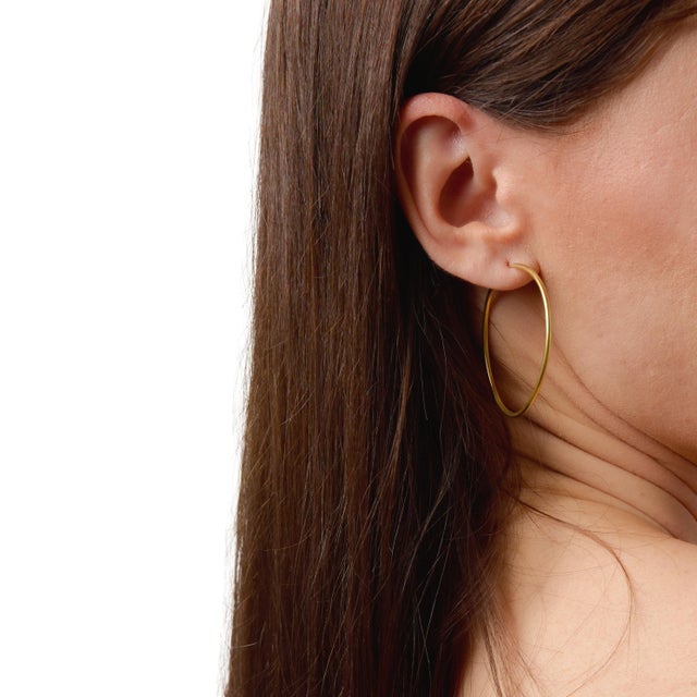 These classic hoop earrings showcase a clean and polished design, offering a timeless silhouette that complements any...