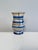 This handcrafted ceramic vase from the 1920s combines clean lines with a striped decoration in cream and azure,...