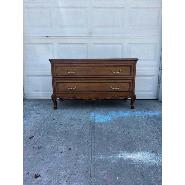 We have a beautiful French Provincial walnut dresser featuring a classic Louis XV style silhouette with clean lines,...