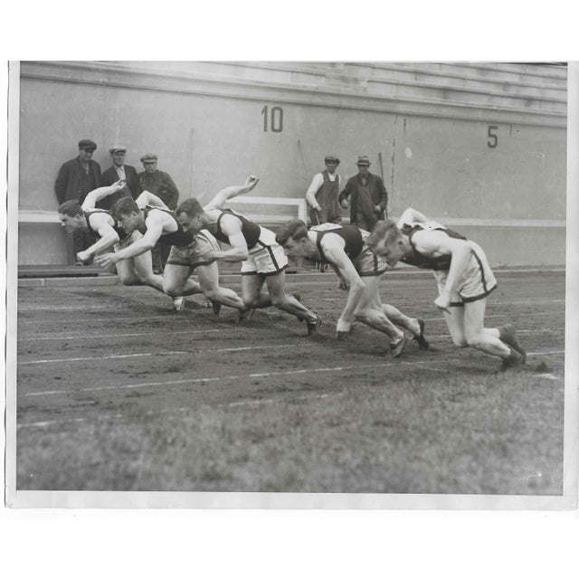 1930 Harvard track team competes in the 440 yard dash. Publication information written on the back.
