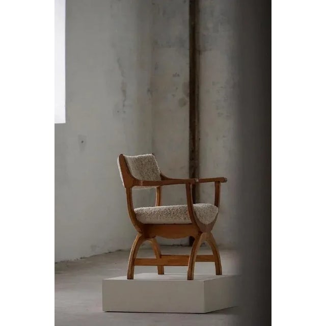 A fine and elegant armchair in solid oak, reupholstered in quality shearling lambswool. Designed by henning (henry)...