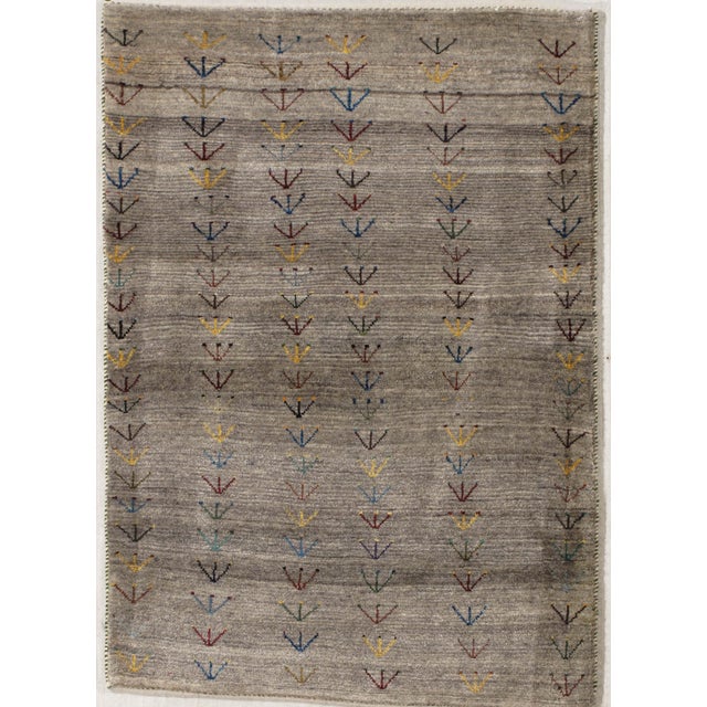 Hand-knotted Persian Gabbeh wool rug with a gray field decorated with vertical rows of small stylized plant motifs in...