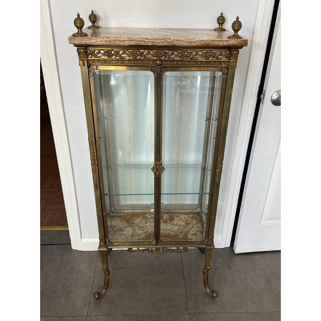 Elegant and finely detailed, this antique French brass-framed vitrine cabinet dates to the late 19th–early 20th century...