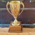 Here is a gold tone over metal cup trophy on a solid two tiered solid walnut base from the early 1960’s. No engraving.