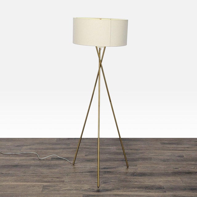 This West Elm floor lamp features a sleek tripod base in a gold finish and a simple beige drum shade. Its modern design...