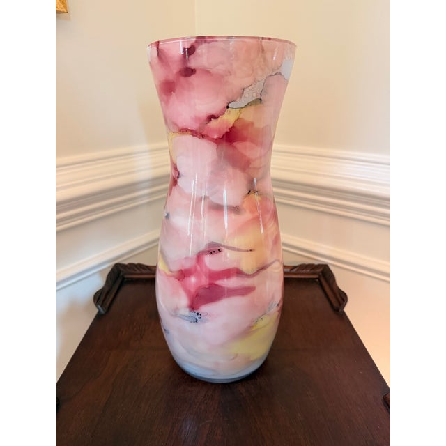 Striking decorative art glass vase featuring a dreamy, watercolor-like abstract pattern in layered shades of blush pink,...