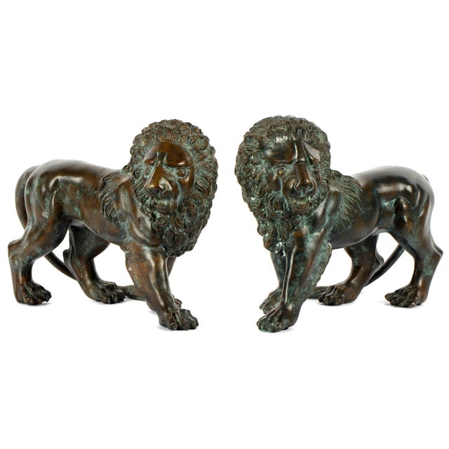 Elegant Mirror-Image Pair of Continental Bronze Lion Sculptures. Sculptures are finely cast with expressive facial...