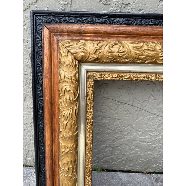 Beautiful ornate wood frame with a gilded inner molding, a carved wood mid-section and a black outer border. Vintage. Can...