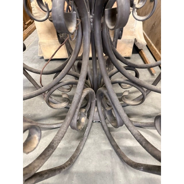 Stunning, oversized vintage-style wrought iron chandelier. This massive statement piece features and elegant cage-top...