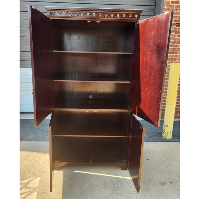 Cabinet in a dark brown and silver finish, offering a striking mix of mirrored detail, storage, and sculptural presence....