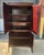 Cabinet in a dark brown and silver finish, offering a striking mix of mirrored detail, storage, and sculptural presence....