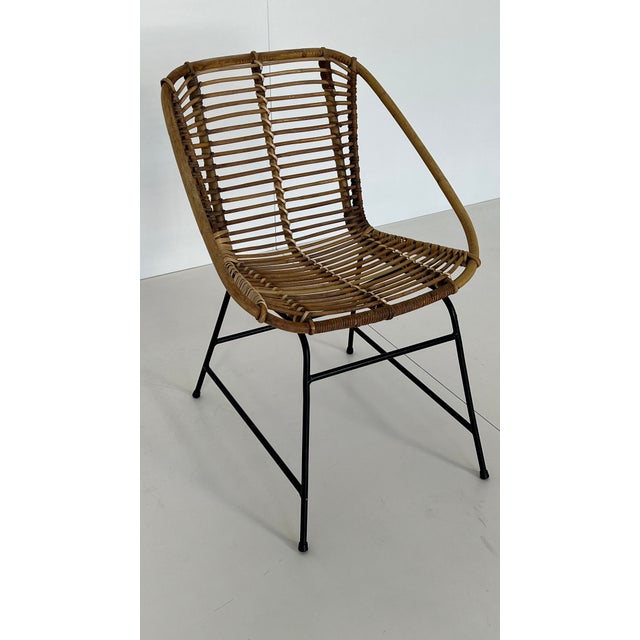 Woven rattan lounge chair, Italian design. Fits perfectly into a minimalist 1960s lounge setting. Matte black metal base....