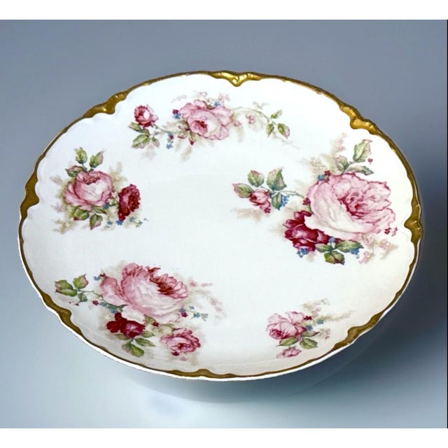 A beautifully hand‑decorated Haviland & Co. Limoges porcelain plate featuring lush pink roses, soft green foliage, and...