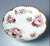 A beautifully hand‑decorated Haviland & Co. Limoges porcelain plate featuring lush pink roses, soft green foliage, and...
