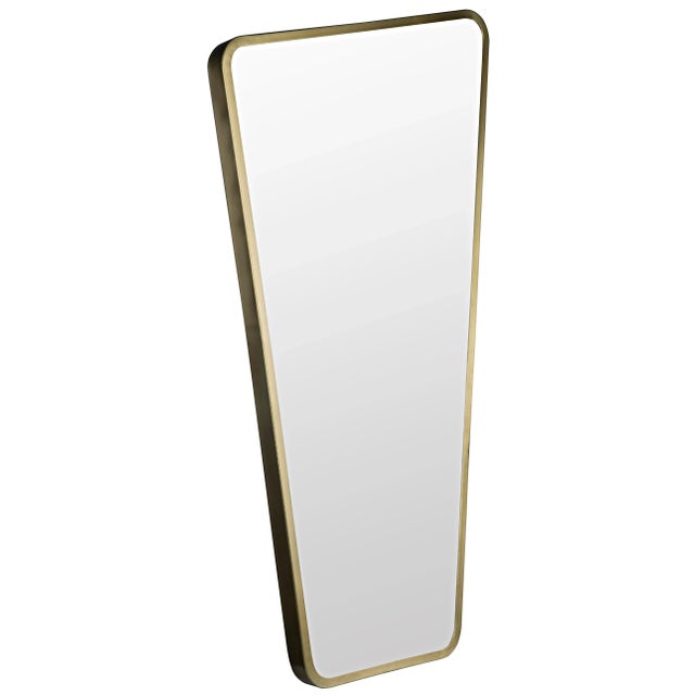 A slim band of metal surrounds this polished wall mirror. The burnished antique brass finish of the frame warms the look...