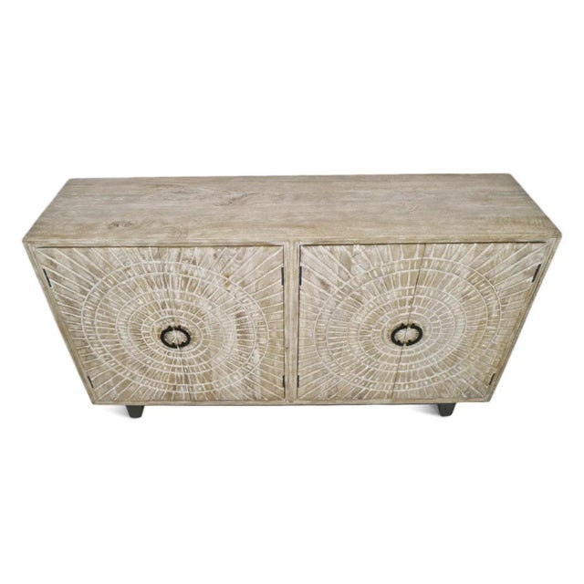 Solid mango wood sideboard with beautiful carved medallion design on four doors. White washed finish on mango wood. Black...