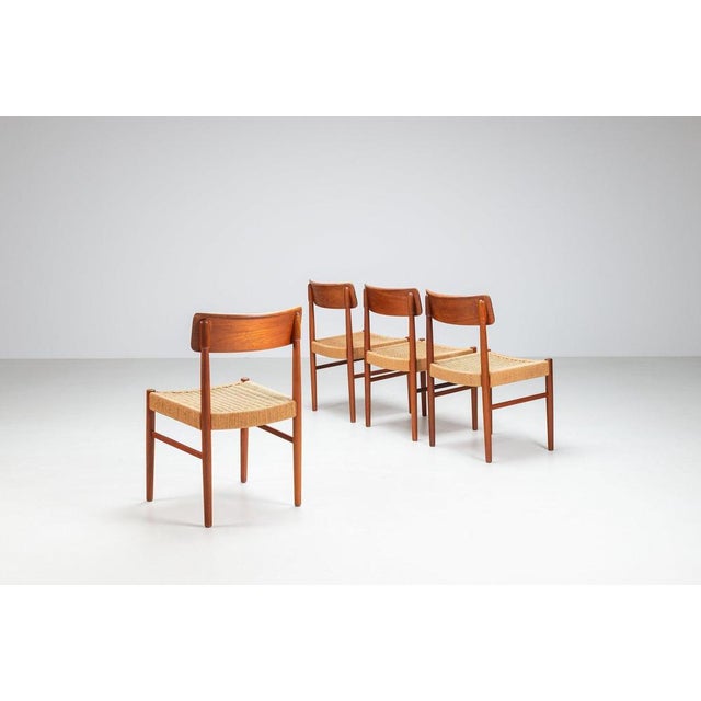Set of four Danish dining chairs in teak and paper cord, Denmark, 1960s. An elegant set of mid-century dining chairs...