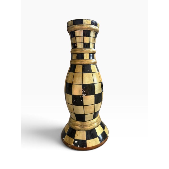 Striking vintage black and gold candlestick featuring a bold hand-painted checkerboard pattern over a turned, classical...