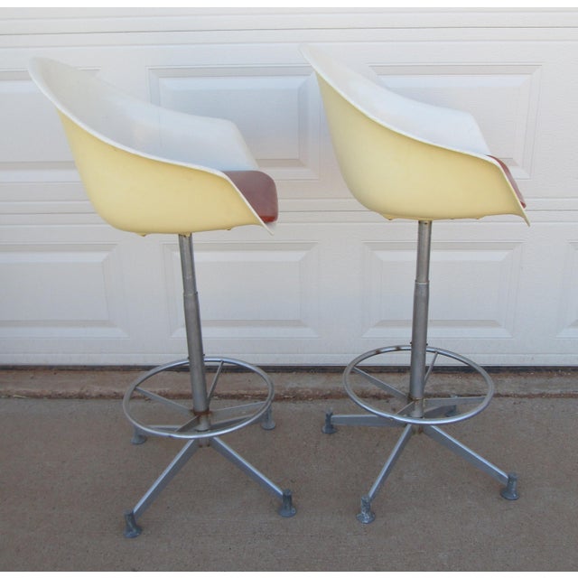2 Hamilton Cosco molded fiberglass swivel bar stools. Each is white fiberglass with a red vinyl seat insert .They each...