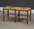A Danish country modern seagrass two seater bench with oak legs. Made in Denmark. Circa 1970’s. 34.25” wide. 15.75” deep....