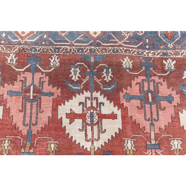 This antique Persian Heriz rug dating back to circa 1930 beautifully captures the essence of its mother-town...