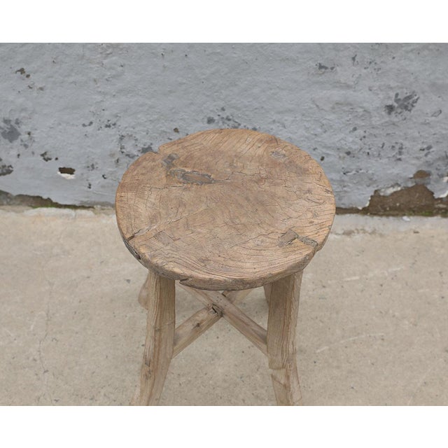 A charming vintage Chinese stool crafted from solid elmwood, dating to the first half of the 20th century. The round seat...